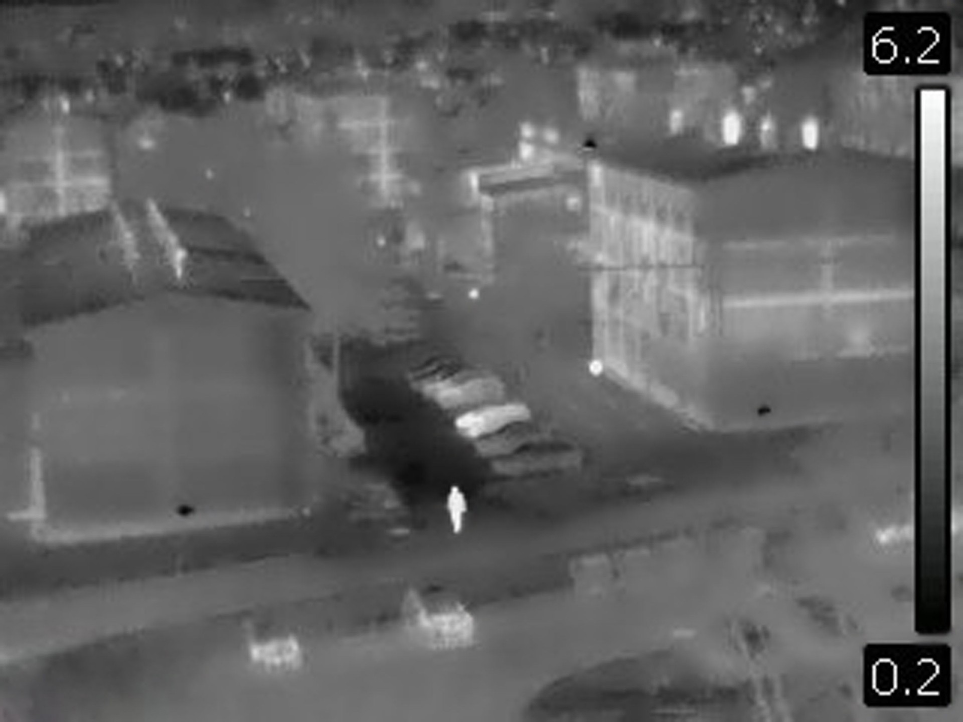 Night vision image  of man walking down the street